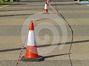 Traffic cones with barricade tape on the road