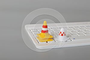 Traffic cones and laptop keyboard.Computer system under construction, repair and maintenance concept