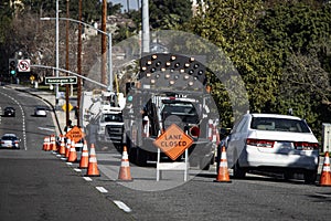 Traffic cones in a line with a a right lane closed sign and electronic traffic arrow photo