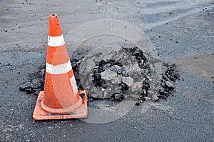 Traffic cones and mounds of asphalt