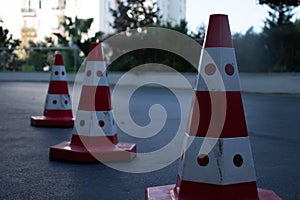 Traffic cones on road with electronic arrow pointing to the right to divert traffic and white car in distance photo