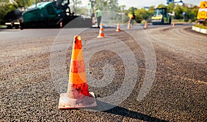 Traffic cones on road. A large layer of fresh hot asphalt. Road construction
