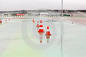 Traffic cones and sprinklers on wet speedway