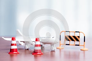 Traffic cones and toy airplane on wooden table with copyspace