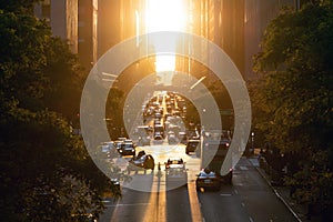 Traffic congestion with cars, taxis and buses on 42nd Street in Midtown Manhattan New York City with sunset shining between