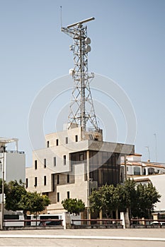 Traffic control tower of boats in the port of Chipiona over building and blue sky photo