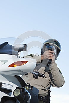 Traffic Cop Monitoring Speed Through Radar Against Sky