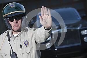 Traffic Cop Signaling Stop Gesture With Car In Background