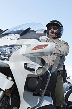 Traffic Cop Sitting On Bike Against Sky