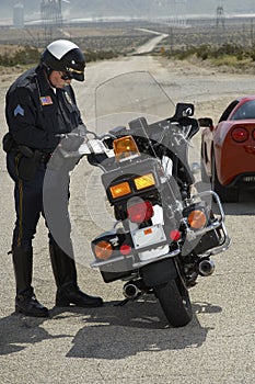 Traffic Cop Writing Against Motorcycle