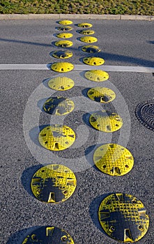 Traffic element retarder yellow round points in two rows on a road asphalt lawn
