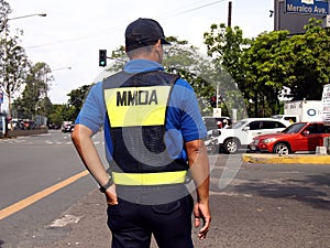 A traffic enforcer stands at a road intersection