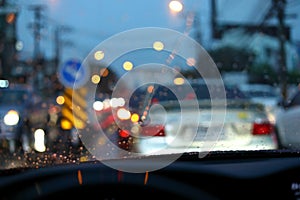 Traffic jam on night road city with storm rainy day weather, car driving on street town with water rain drop