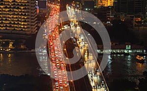 Traffic jam in the rush hour on highway bridge. Busy cars on bridges and roads in Bangkok Downtown, Thailand at night