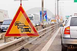 Traffic jam sign on a highway with line of cars waiting in row