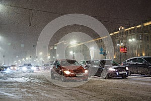 Traffic jam on winter road during snow blizzard at night, transport collapse after snowfall