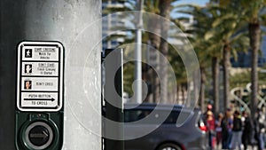 Traffic light button on pedestrian crosswalk, people have to push and wait. Traffic rules and regulations for public