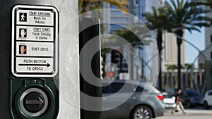 Traffic light button on pedestrian crosswalk, people have to push and wait. Traffic rules and regulations for public