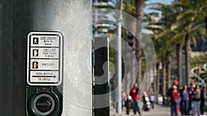 Traffic light button on pedestrian crosswalk, people have to push and wait. Traffic rules and regulations for public safety in USA