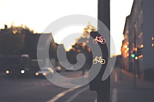 traffic light for a cycling lane showing red and yellow bicycle symbol at a frequented intersection in dark early morning light photo