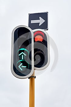 Traffic light, green and arrow with stop at street intersection for transportation directions, driving or downtown. Road