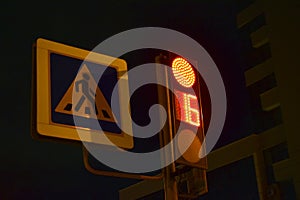 Traffic light at the intersection at night for pedestrians and cars