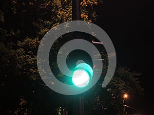 Traffic light at night-time showing green