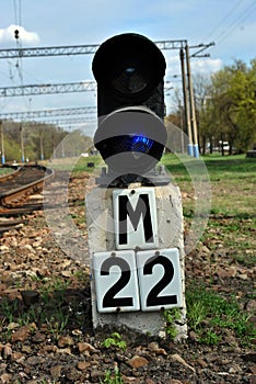 Traffic light on a railway with a sign of `22 meters`