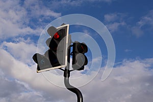 Traffic light on red against deep blue cloudy sky with copyspace