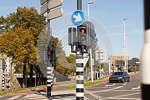 Traffic light-regulated intersection with road signs. Red traffic light