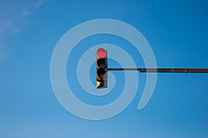 Traffic light showing red with blue sky background