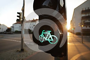 A traffic light shows green bicycle symbol at an european intersection in uplifting and inspiring morning light