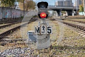 Traffic light shows red signal on railway. Railway station