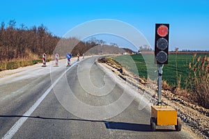 Traffic light signalization during road maintenance, red stoplight for traffic regulation photo