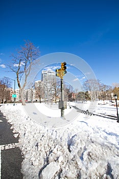 Traffic light on snow with buildings and blue sky