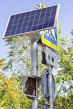 Traffic light working on solar power. Solar panel powering digital display of a traffic light. vertical