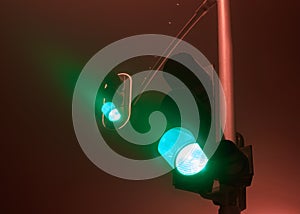 Traffic lights with green light during a foggy night