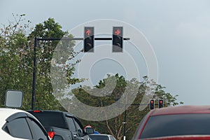 Traffic lights that are red indicate to stop and there are many cars waiting