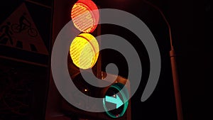 Traffic lights with red light and green arrow pointing to the right and left, handheld shot. Close up of traffic lights