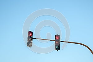 Traffic lights showing red in all directions against the blue sk