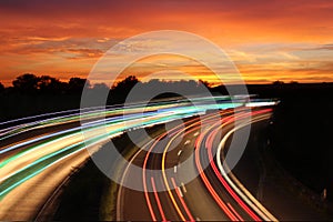 Traffic with motion cars with luminous speed lines and evening sky with beautiful sunset sky, natural landscape