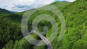 Traffic on the mountain road at the sunny day aerial view