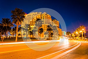 Traffic moving past a hotel and palm trees on Coronado Drive at