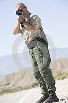 Traffic Officer Monitoring Speed Through Radar Gun