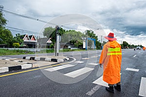 Traffic officer wearing orange raincost with control and directing traffic in countryside