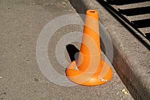 A traffic orange cone is used as a barrier during road construction work