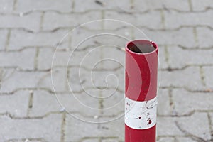 Traffic pole on pavement for safety Area close up. Red and white striped road barrier. Metal pole to prevent cars from using path