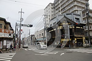 Traffic road with Japanese and foreigner walking and visit street and clay walled warehouse style building at Kawagoe or Little E