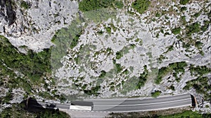 Traffic road between two tunnels in the foots of the rocky mountain. Aerial view