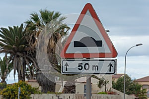 Traffic rules, speed bump road sign with distance sign